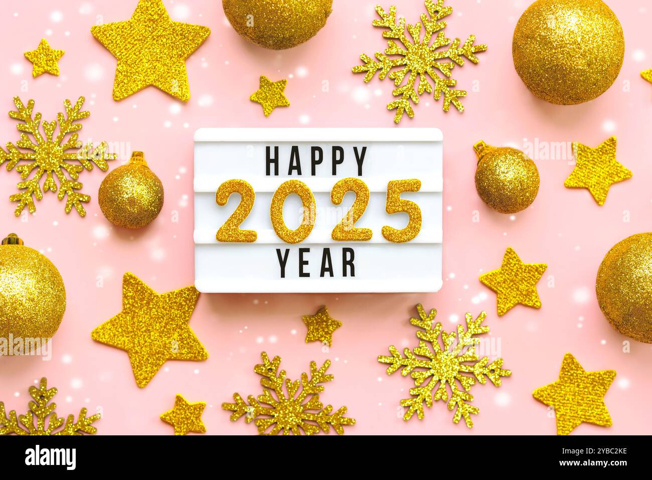 Happy New Year 2025. Top-Blick auf Leuchtkasten mit dem Wort Happy New Year 2025, goldene weihnachtskugeln und goldene Sterne auf rosa Hintergrund. Silvester Stockfoto