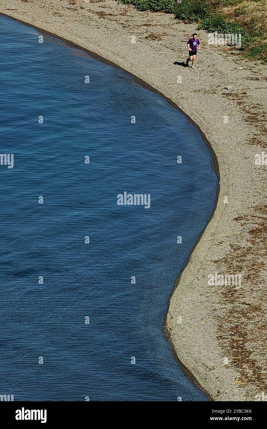 Gesunde Gewohnheiten: Mann, der am Sandstrand am Ohrid Lake läuft, Luftperspektive Stockfoto