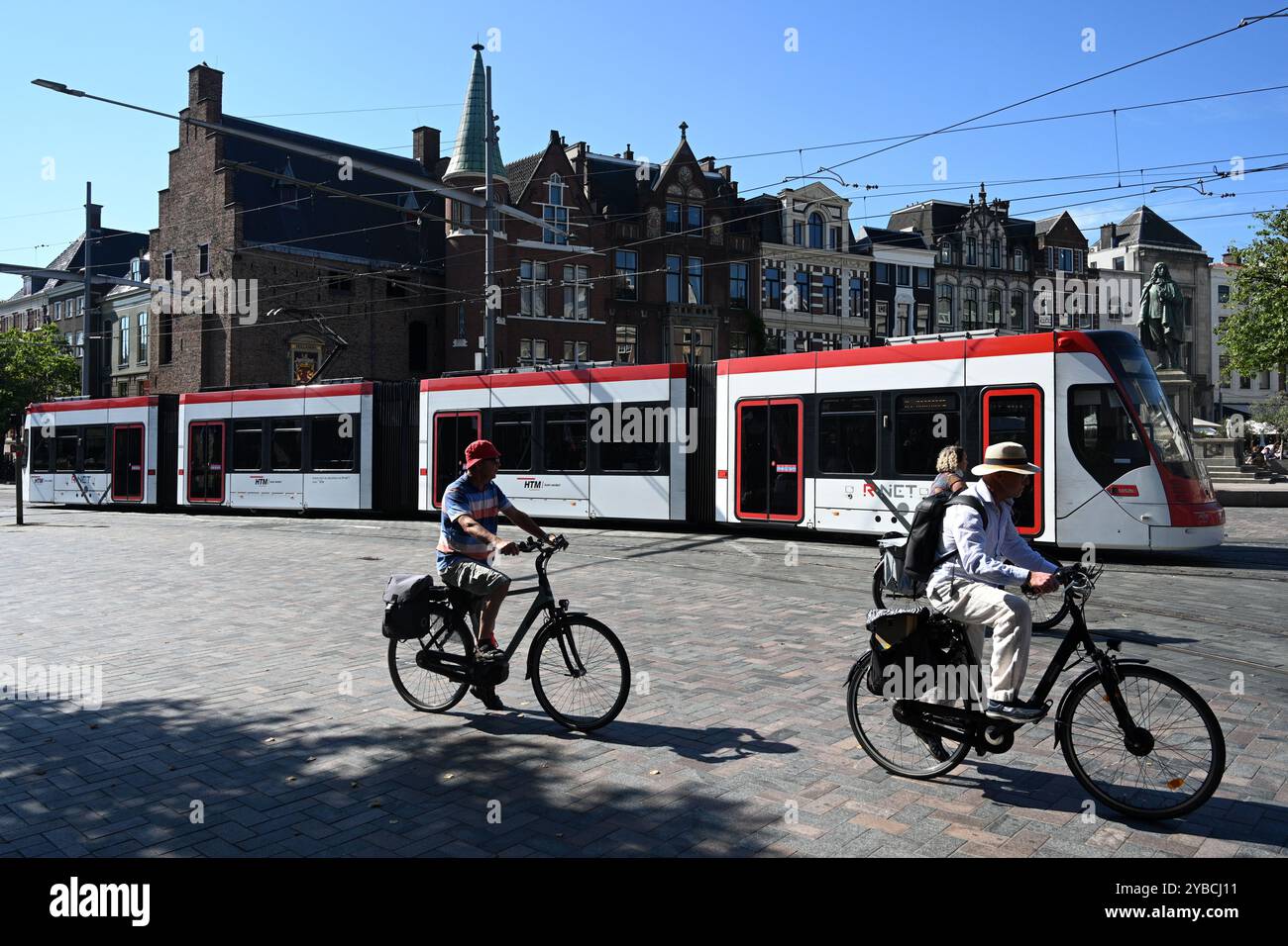 Den Haag, Niederlande - 28. August 2024: Ein Mensch fährt mit dem Fahrrad in der Nähe der Straßenbahn im Zentrum von den Haag Stockfoto