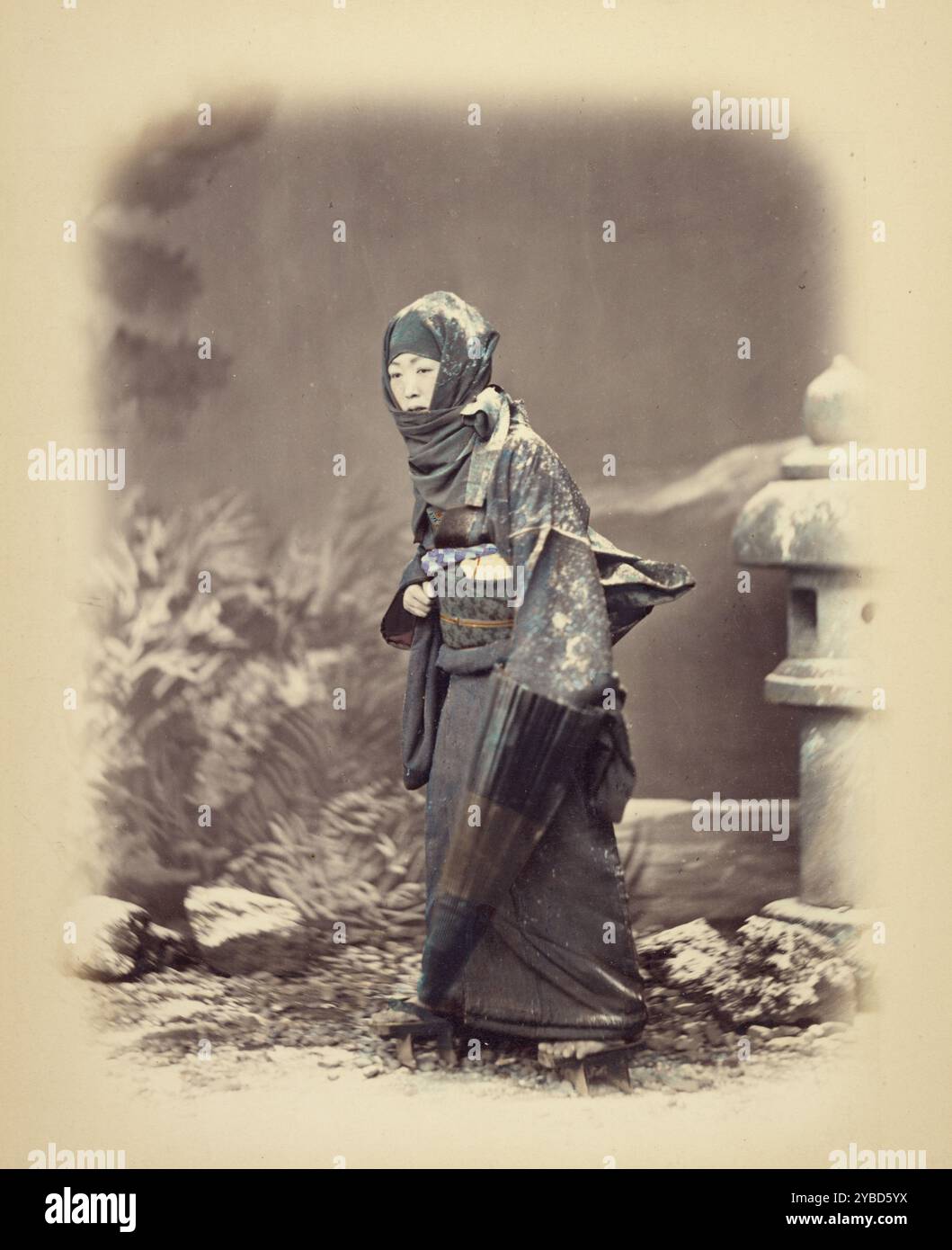 Frau im Winterkleid, ca. 1868. Diese aufwendige Studioszene einer Frau im Winterkleid, die im Schnee spaziert, erinnert an traditionelle japanische Holzschnitte. Stockfoto