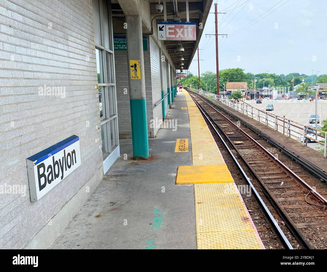 Babylon, New York, USA - 8. Juli 2024: Blick nach Westen auf den erhöhten Bahnsteig an der Babylon Roailroad Station ohne Züge auf den Gleisen. Stockfoto