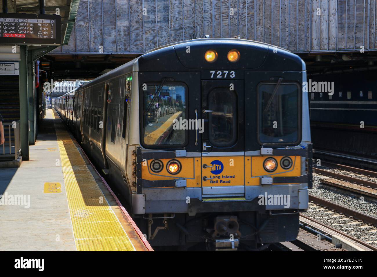 Woodside, New York, USA - 20. August 2024: Züge, die an einem sonnigen Tag an einer stark frequentierten Woodside Transit Station in New York ankommen und abfahren Stockfoto