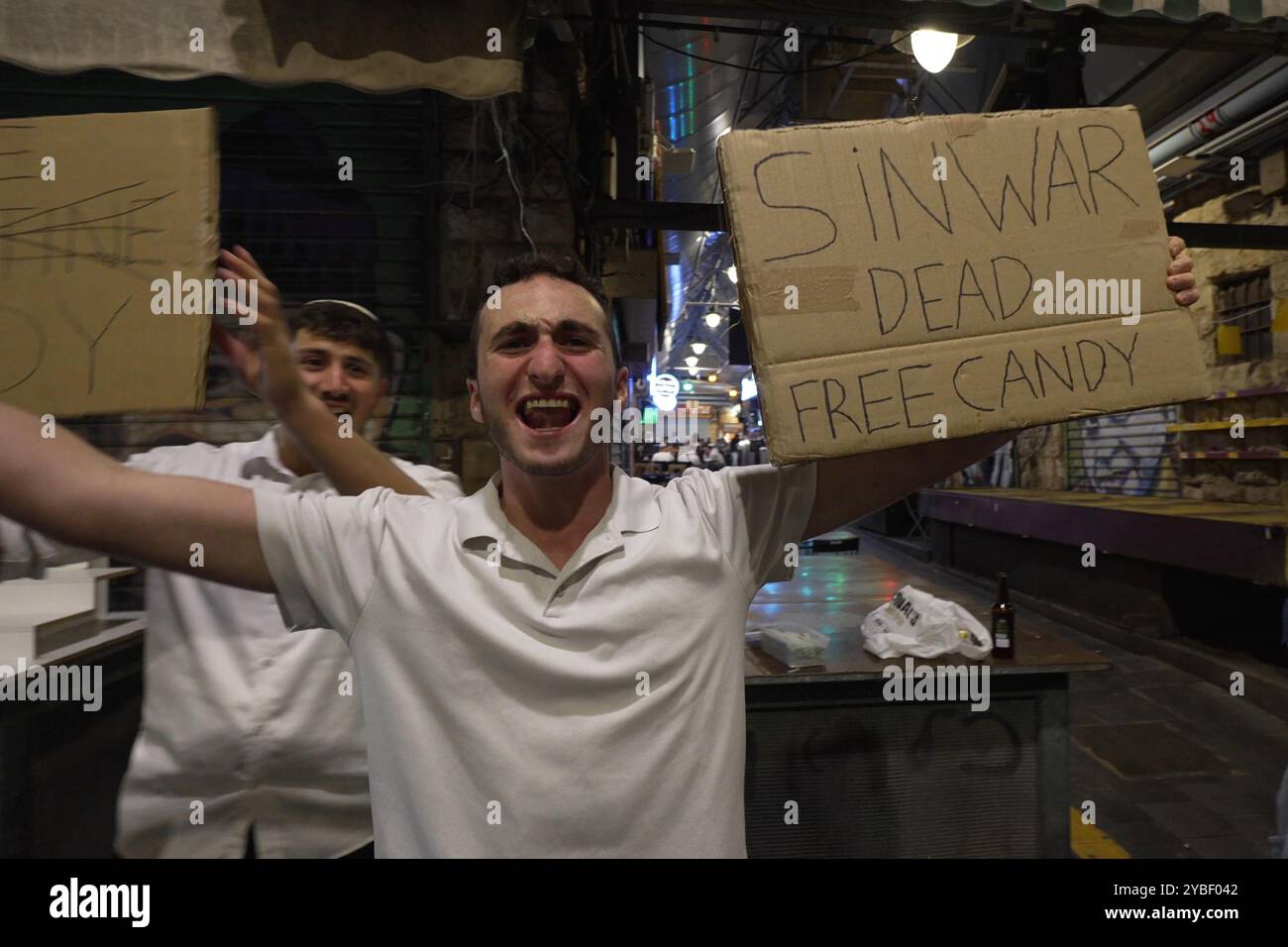 JERUSALEM - 17. OKTOBER: Ein israelischer Mann hält ein Schild mit der Aufschrift „Sinwar tot, kostenlose Süßigkeiten“, während die Israelis die Nachricht vom Tod des Hamas-Führers Yahya Sinwar in Gaza am 17. Oktober 2024 in Jerusalem feiern. Israel bestätigte den Tod von Sinwar, dem Drahtzieher des Angriffs vom 7. Oktober, und nannte es einen großen Rückschlag für die palästinensische Gruppe, die es seit mehr als einem Jahr kämpft. Stockfoto