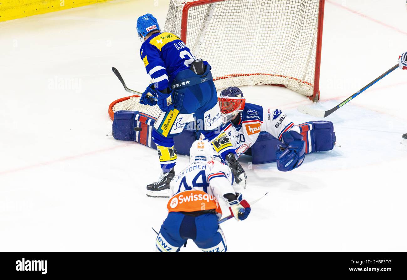 Kloten, Schweiz, 18. Oktober 2024: #29 Niko Ojamäki (Kloten) will Torhüter #30 Simon Hrubec (ZSC Lions) mit der Rückhand schlagen. Der Torwart spart mit den Beinpolstern. (Foto: Andreas Haas/dieBildmanufaktur) Credit: DieBildmanufaktur/Alamy Live News Stockfoto