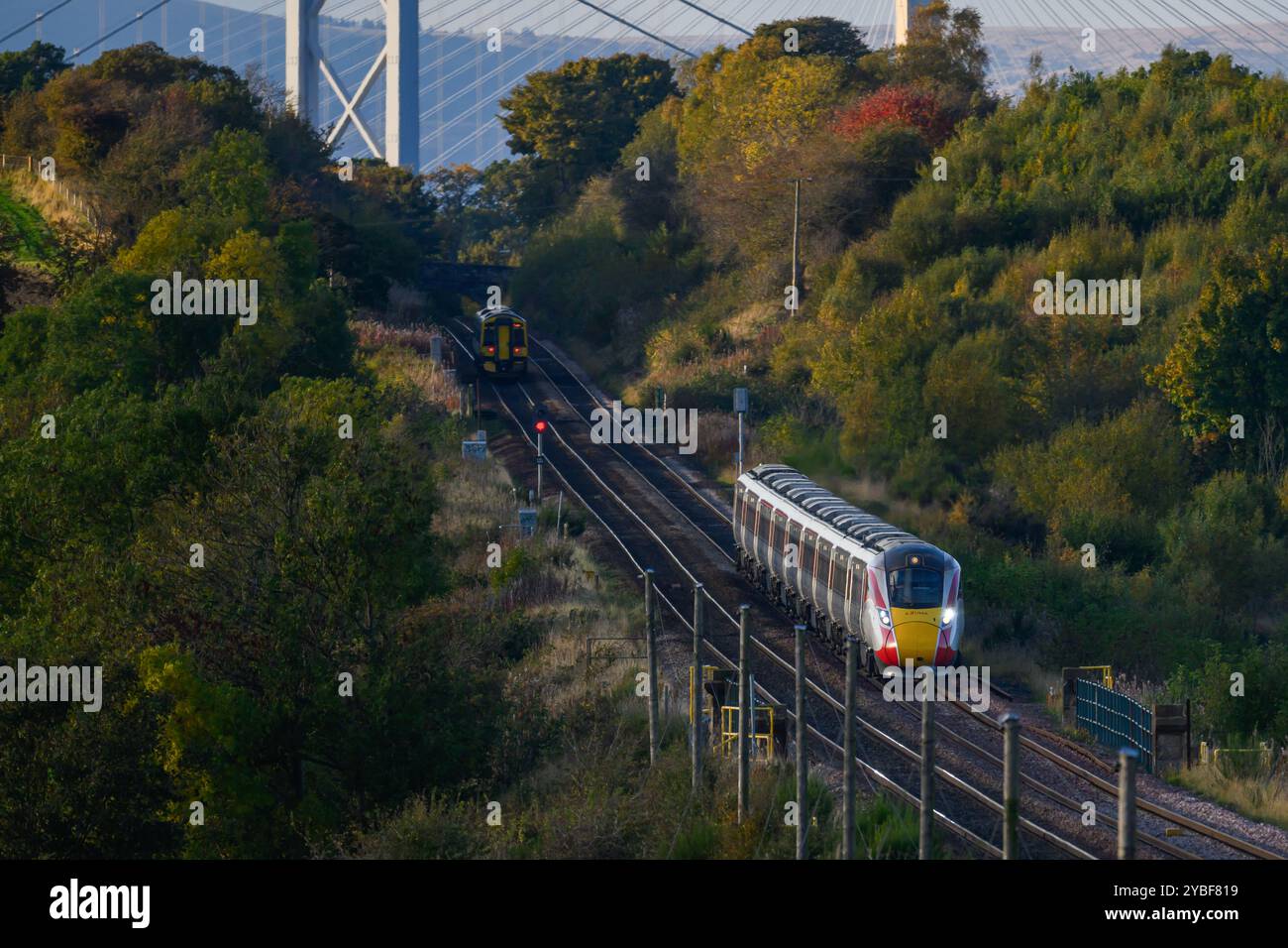 Mit der Forth Bridge & Queensferry Crossing im Hintergrund fährt Ein LNER Azuma Train zwischen den Stationen Dalmeny und Edinburgh Gateway in Schottland, Großbritannien Stockfoto