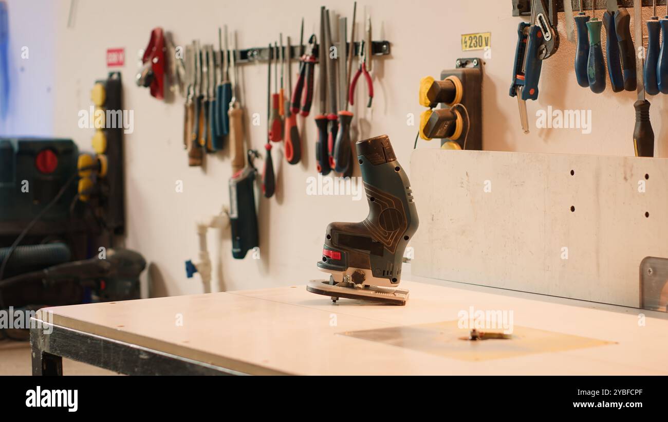 Nahaufnahme des elektrischen Fräsers auf Holzformmaschine in der Tischlerei zum Präzisionsschneiden von Holzblöcken. Schwerpunkt auf Elektrowerkzeug für Spindelfräser, die in der Holzbearbeitung und beim Schwenken eingesetzt werden Stockfoto