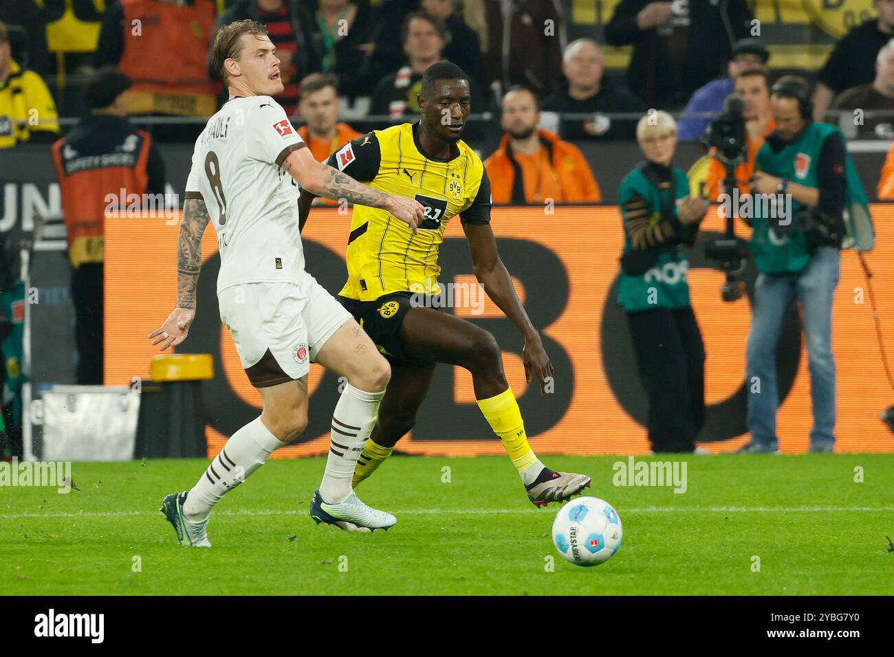 Dortmund, Deutschland. Oktober 2024. Serhou Guirassy (R) von Borussia Dortmund streitet mit Eric Smith vom FC St. Pauli während ihres ersten Bundesliga-Fußballspiels in Dortmund, Deutschland, am 18. Oktober 2024. Quelle: Joachim Bywaletz/Xinhua/Alamy Live News Stockfoto