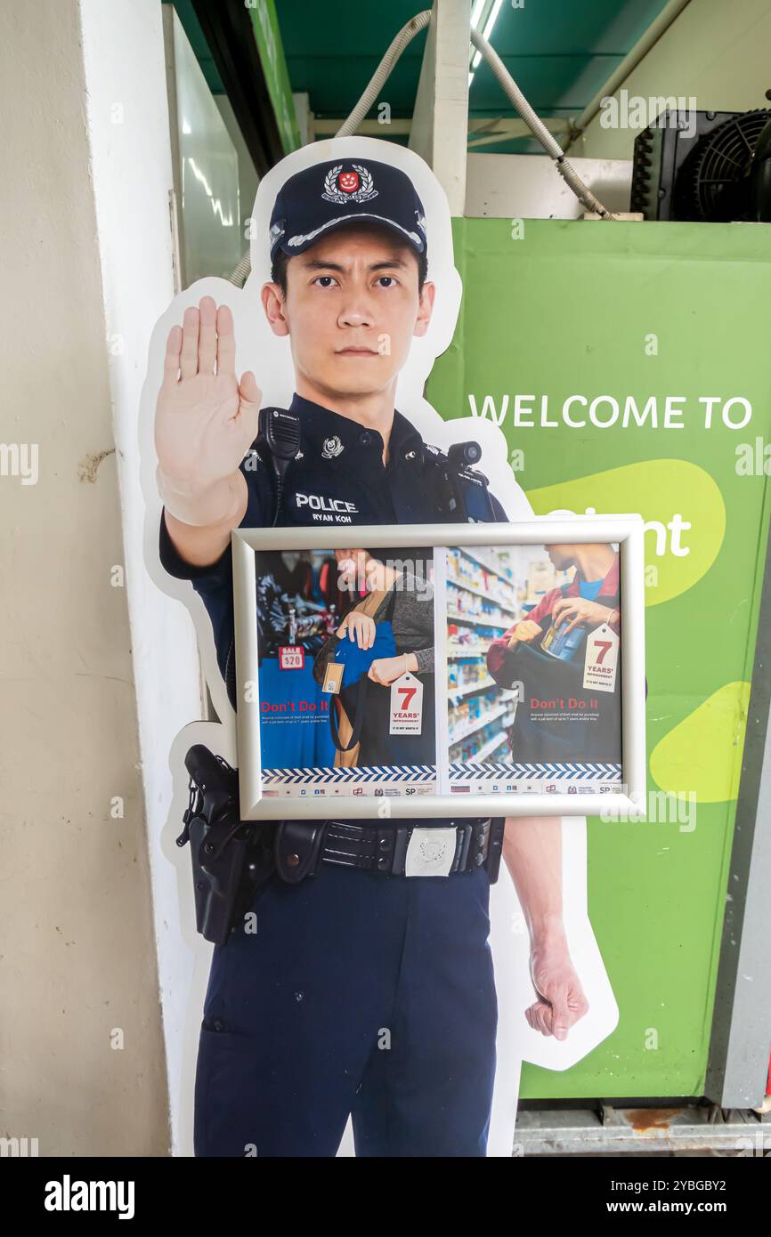 Warnung vor Ladendiebstahl, Diebstahlschutz und Diebstahlschutz Poster, auf dem ein Polizist mit einer Hand im Einzelhandelsgeschäft in Singapur gezeigt wird Stockfoto