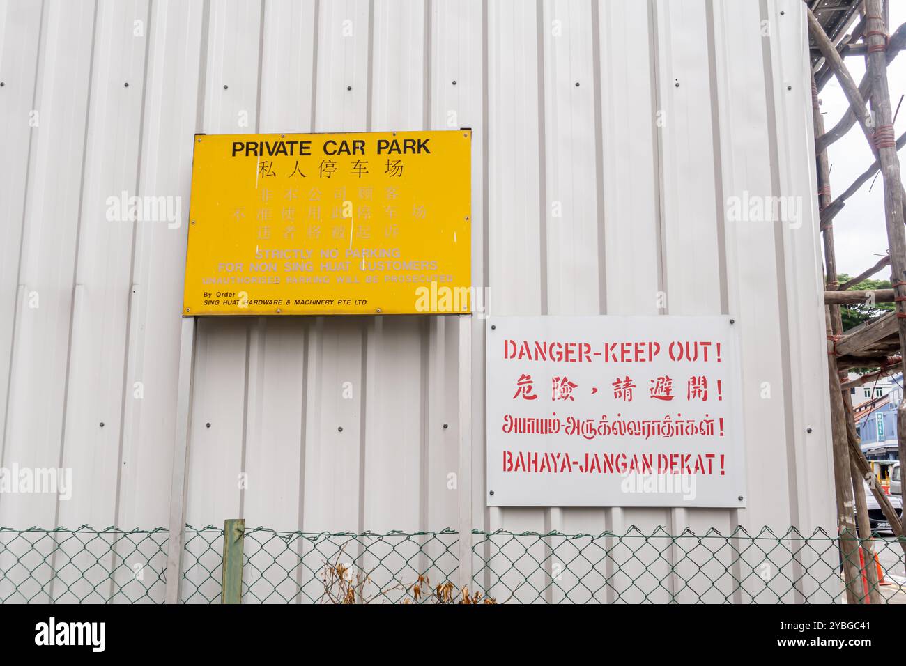 Zweisprachiges Schild für Privatparkplätze - "Danger Keep Out"-Schild in vier Sprachen - Malaiisch, Chinesisch, Thai, Englisch, Singapur Stockfoto