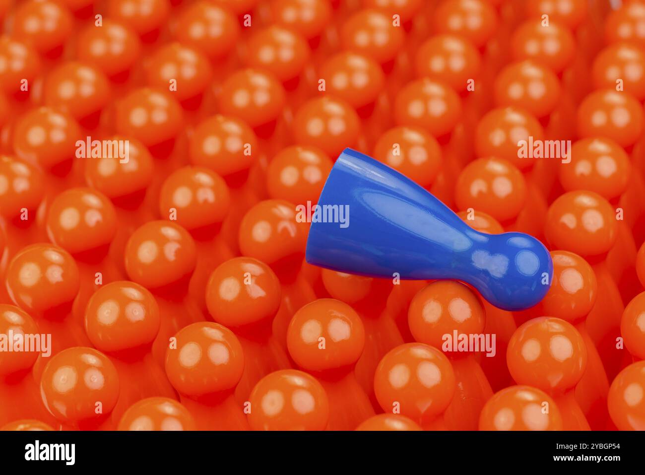 Konzeptionelle orange Spiel Bauern und einen blauen Play Bauern als abstrakte Darstellung von Ungleichheit in Farbe und Anzahl der Stockfoto