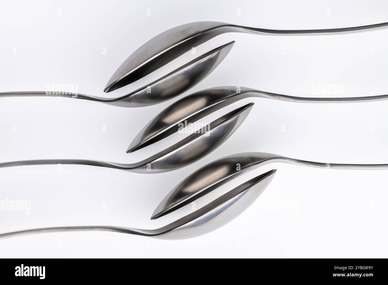 Abstraktes künstlerisches Foto von Ort Einstellung, wobei sechs Löffel vor einem weißen Hintergrund Stockfoto