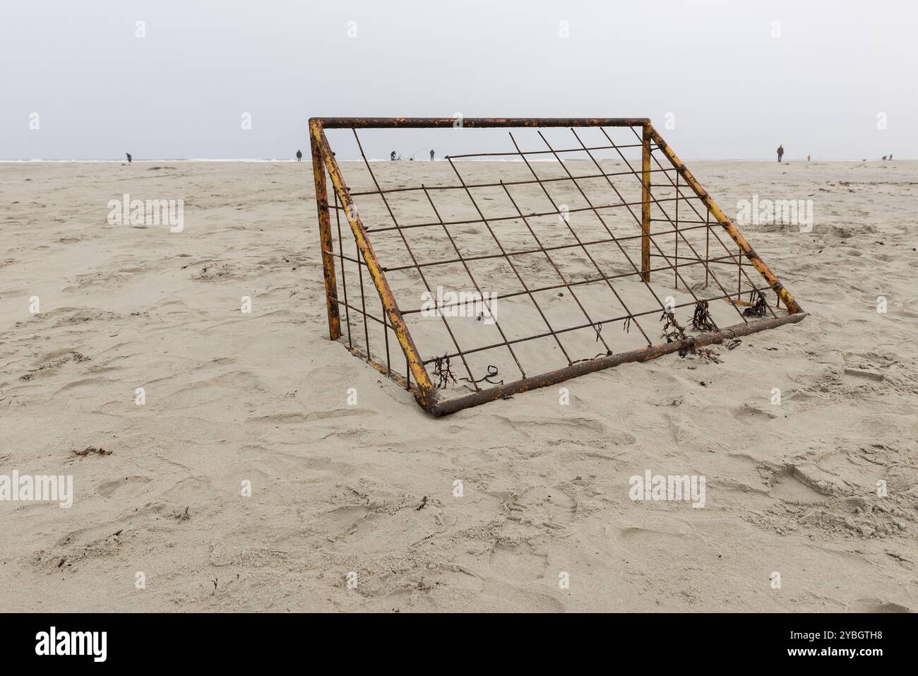Verrostete Fußballtor an einem Strand mit Fischer auf dem Meer auf der Insel Terschelling in Niederlande Stockfoto