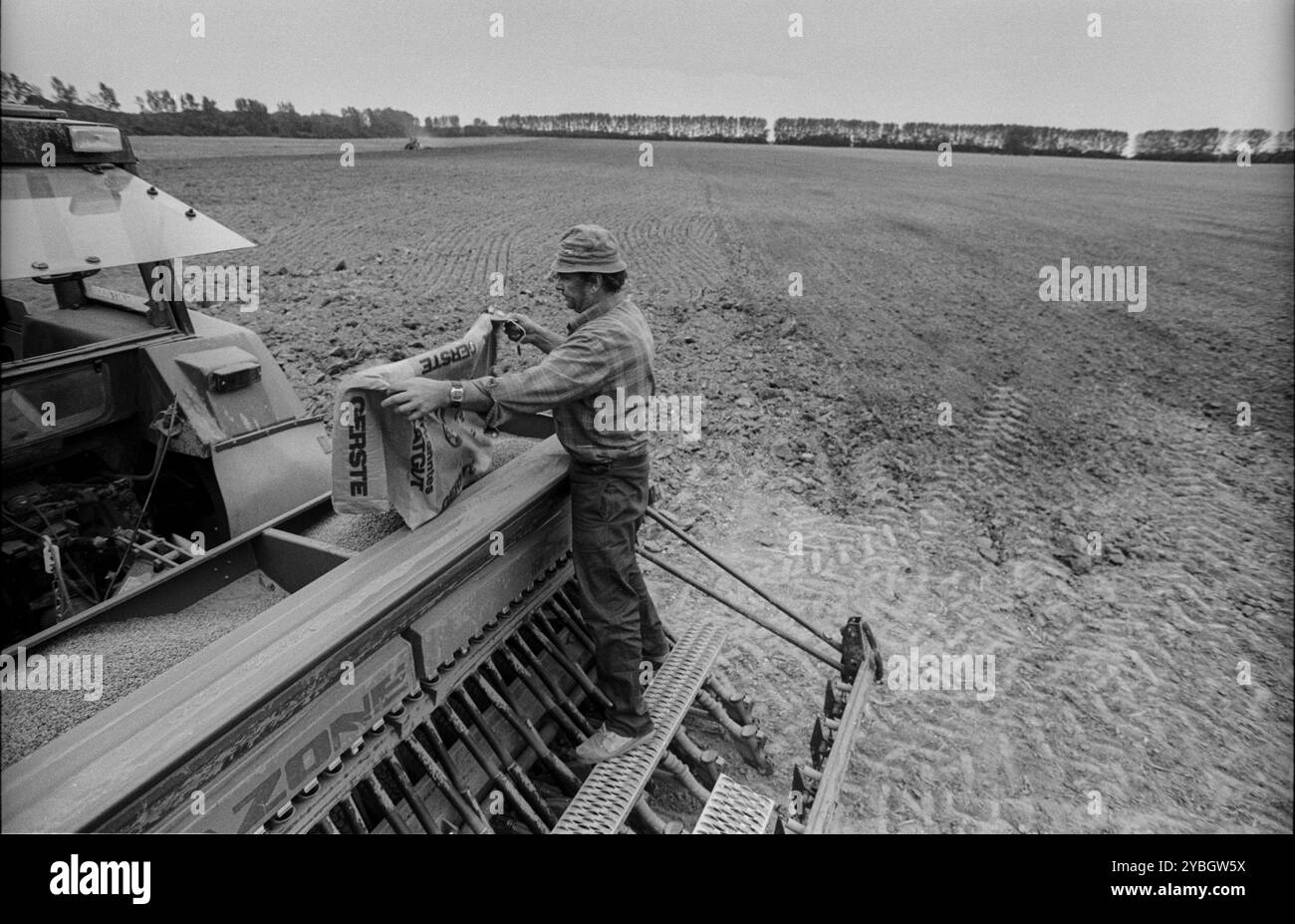 Deutschland, Eixen, 16.9,1991, Traktorfahrer, selbständiger Landwirt, Saatgut wird aufgefüllt, Europa Stockfoto