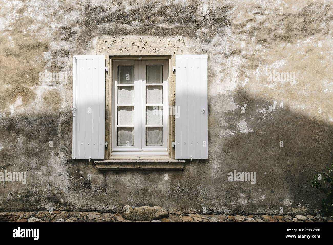 Alte Fenster mit Holz weiß lackiert offenen Rollläden in verwitterten Putz an der Wand Stockfoto