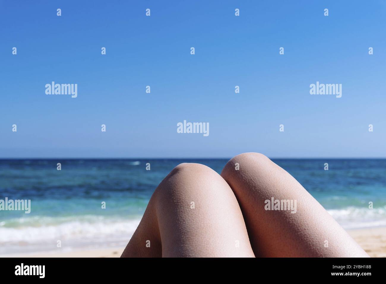 In der Nähe der reifen Frau Beine Sonnenbaden am Strand gegen blaue Meer Hintergrund Stockfoto