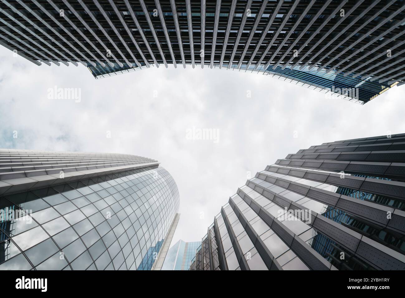 London, UK, 25. August 2023: Flacher Blick auf moderne Bürogebäude in der City of London und Reflexionen an der Vorhangfassade. Ansicht gegen Blau Stockfoto