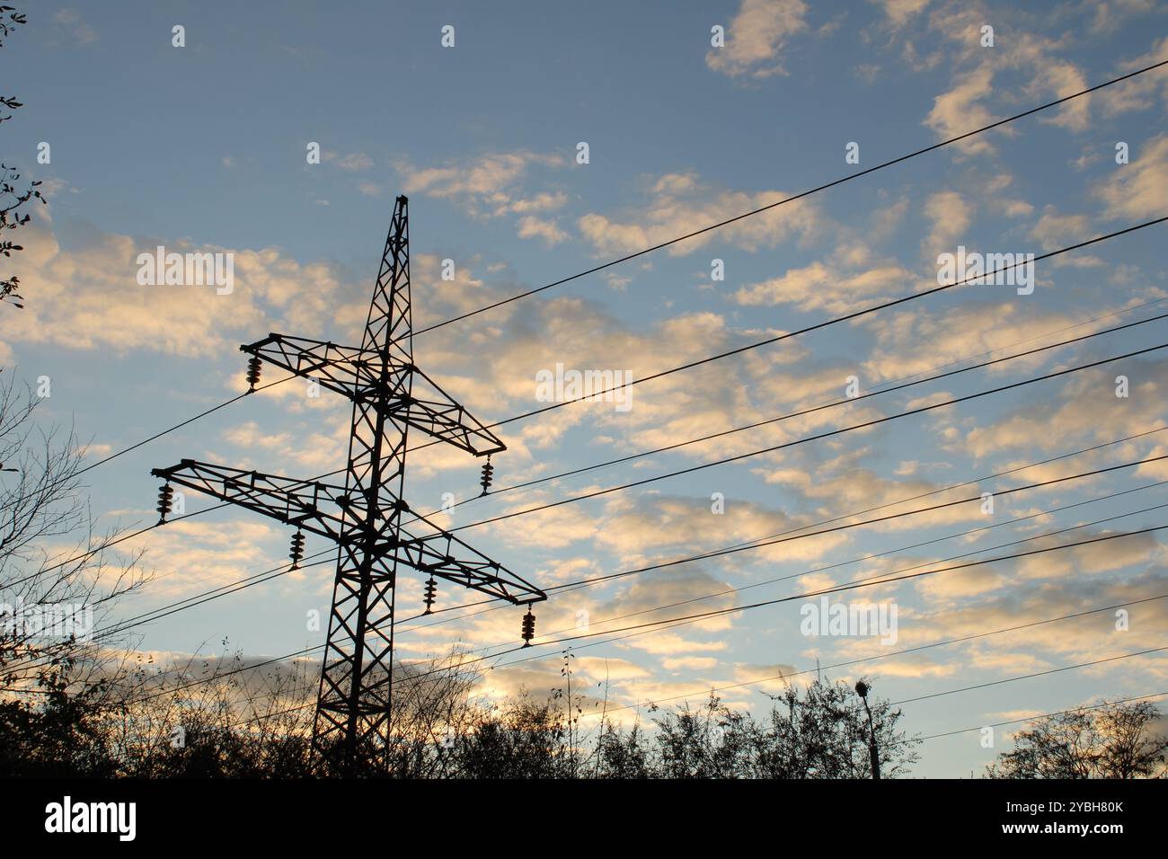 Eine große Metallsäule vor einem blauen Himmel erzeugt einen markanten Kontrast, der das industrielle Element in einer ruhigen natürlichen Umgebung hervorhebt. Stockfoto