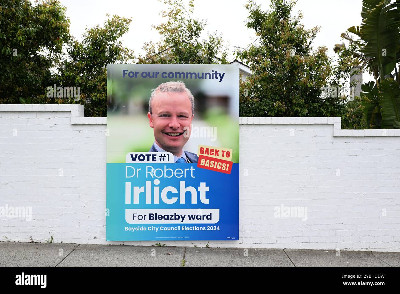 Großes Schild, das Dr. Robert Irlichts Kandidatur bei den Kommunalwahlen des Bayside City Council auf einer weißen Ziegelmauer anpreist Stockfoto