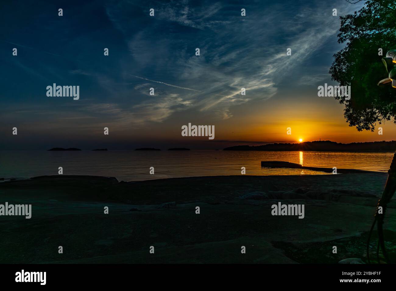 Die untergehende Sonne hinter den Bergen, Panorama der Mittelmeerküste in der Nähe von Rovinj Kroatien Stockfoto