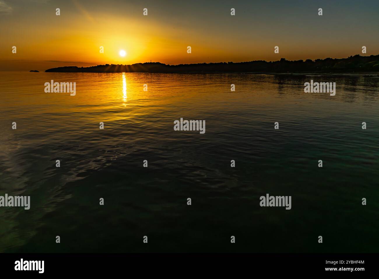 Die untergehende Sonne hinter den Bergen, Panorama der Mittelmeerküste in der Nähe von Rovinj Kroatien Stockfoto