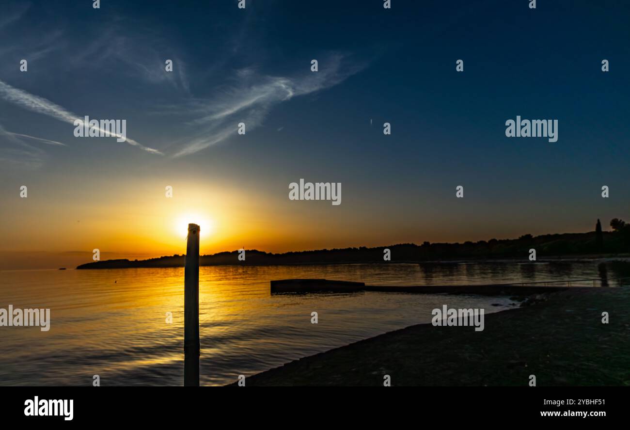 Die untergehende Sonne hinter den Bergen, Panorama der Mittelmeerküste in der Nähe von Rovinj Kroatien Stockfoto