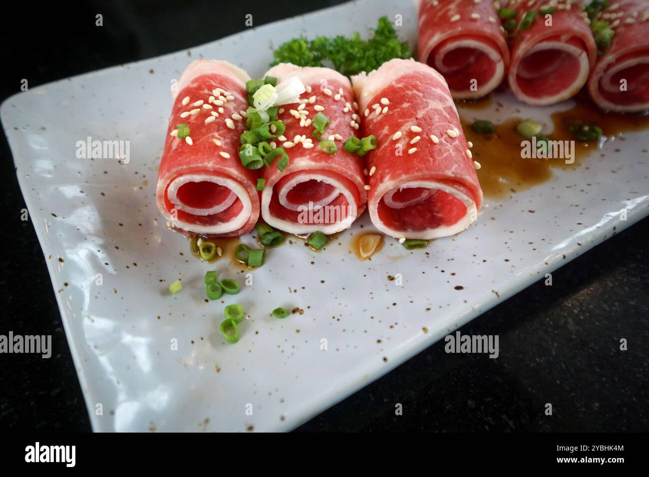 Erstklassige kagoshima Kurobuta Schweineschulterscheibe, serviert auf Keramikplatte mit Sauce und geriebener Schalotte. Stockfoto