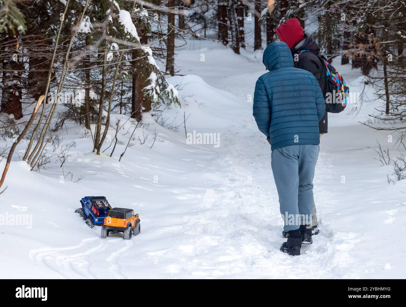 Ein Paar Männer fahren Modellautos in einer schneebedeckten Natur Stockfoto