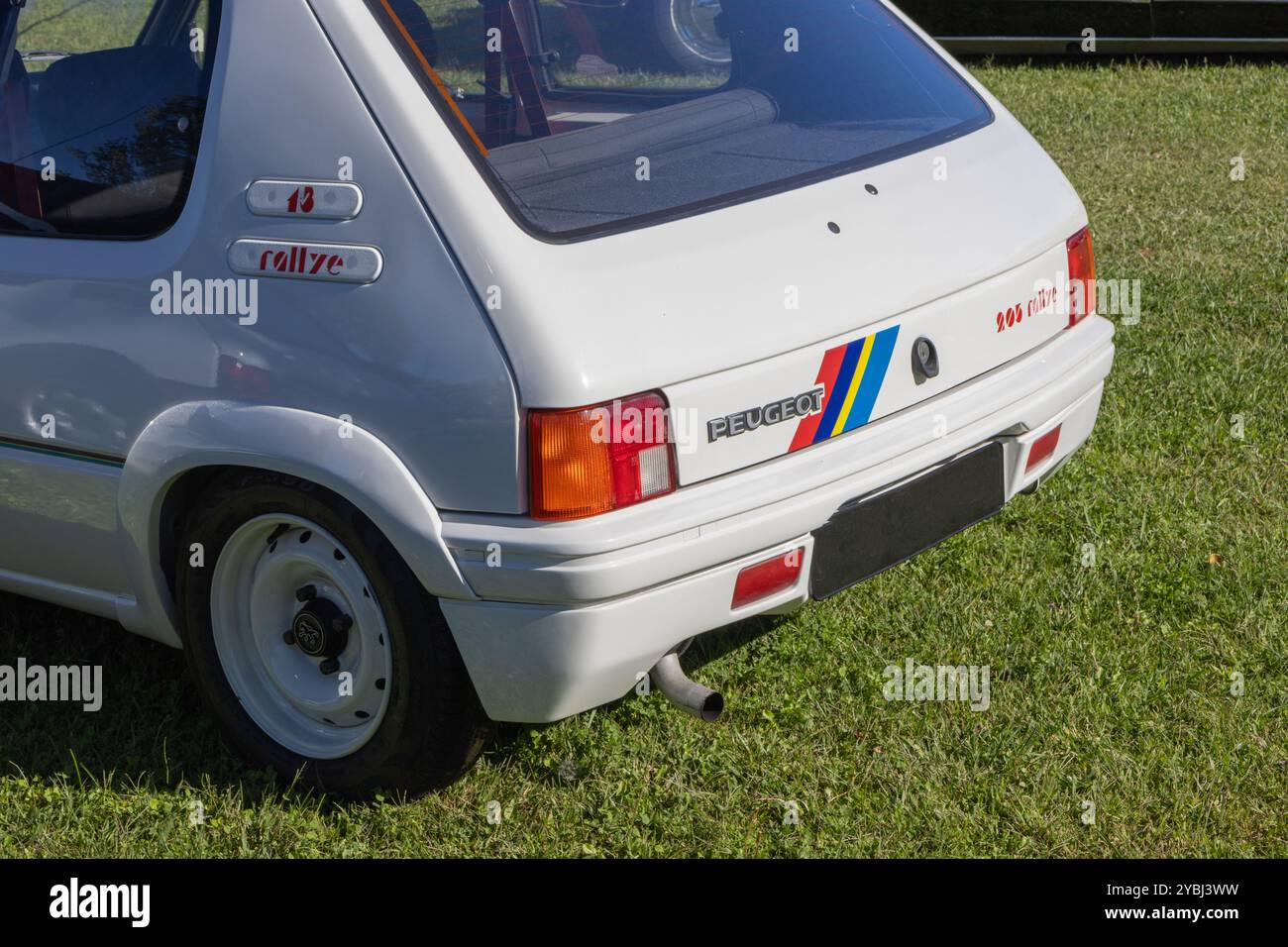Der weiße peugeot 205 Rallye-Wagen mit Rennaufklebern steht auf dem Gras Stockfoto
