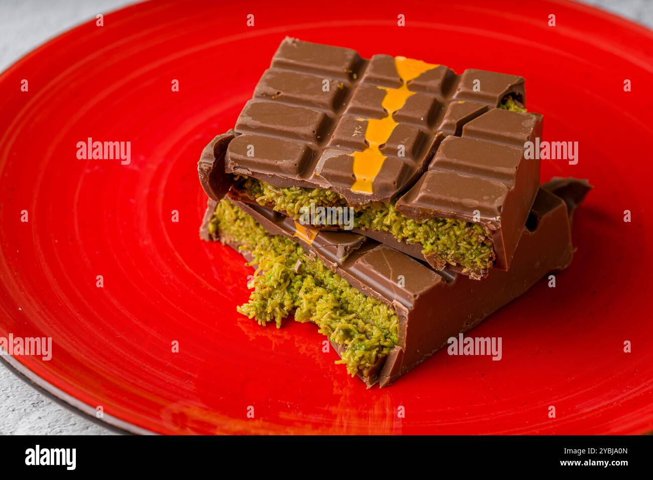 Dubai Chocolate Bar mit grünem Kadayif und Erdnussbutter auf weißem Steintisch Stockfoto