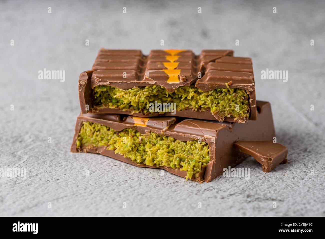 Dubai Chocolate Bar mit grünem Kadayif und Erdnussbutter auf weißem Steintisch Stockfoto