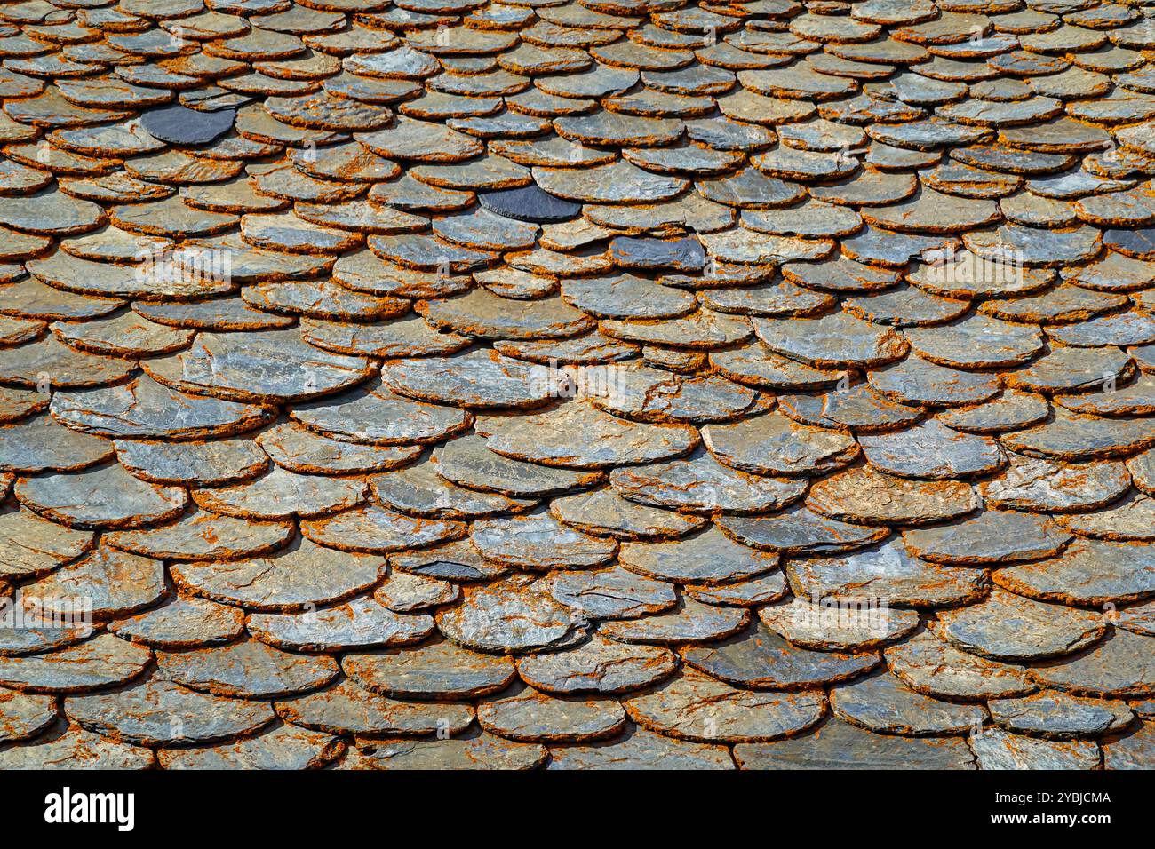 Steingebäude mit Schieferdach und orangefarbenen Flechten, Herbst in Andorra in den Pyrenäen bei Les Bordes d'Envalira Stockfoto