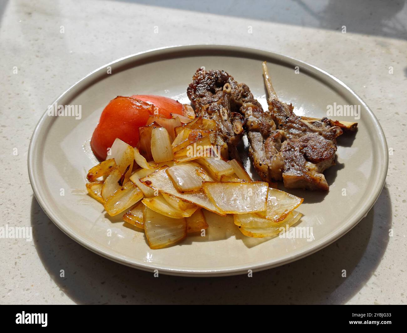Seitenansicht des gegrillten Lammes mit Zwiebeln und Tomaten auf dem Teller zum Essen Stockfoto