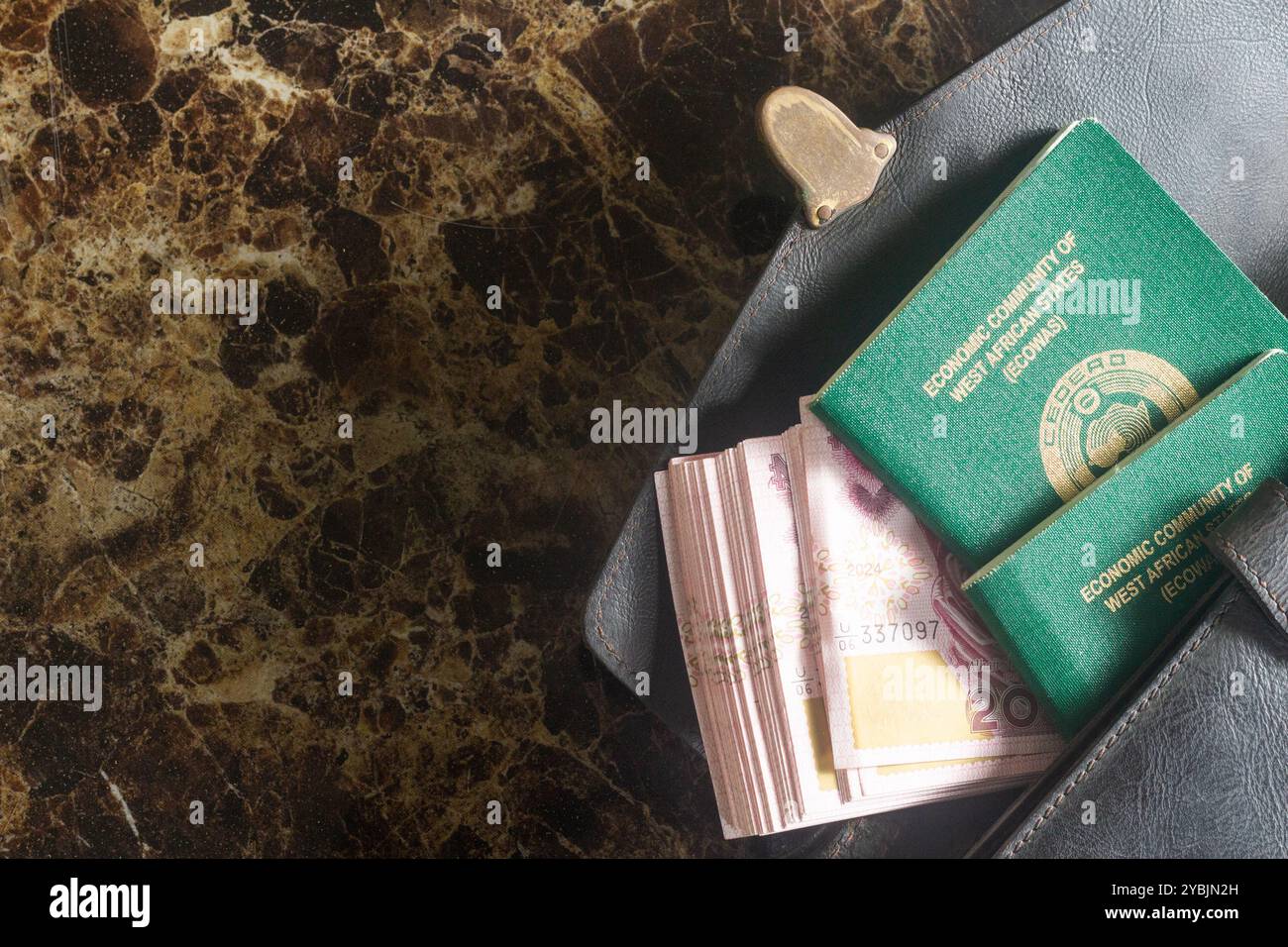 Internationaler Reisepass, Naira, Brieftasche, Kaffee, Taschenrechner, Blutdruckmanschette, Marmortisch symbolisiert Reisen, Währung, Finanzen, Geld, Gesundheit Stockfoto