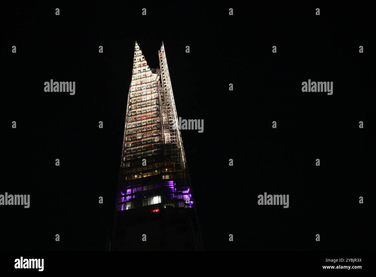 Die Spitze des Shard Wolkenkratzers beleuchtet bei Nacht in London Stockfoto