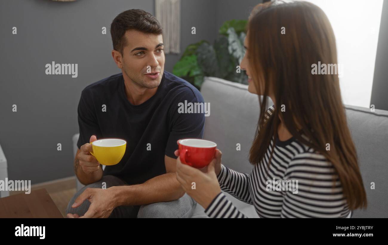 Mann und Frau sitzen auf einer Couch in einem Wohnzimmer, genießen Kaffee zusammen, führen ein Gespräch, zeigen Wärme und Verbundenheit in einem gemütlichen, ich Stockfoto