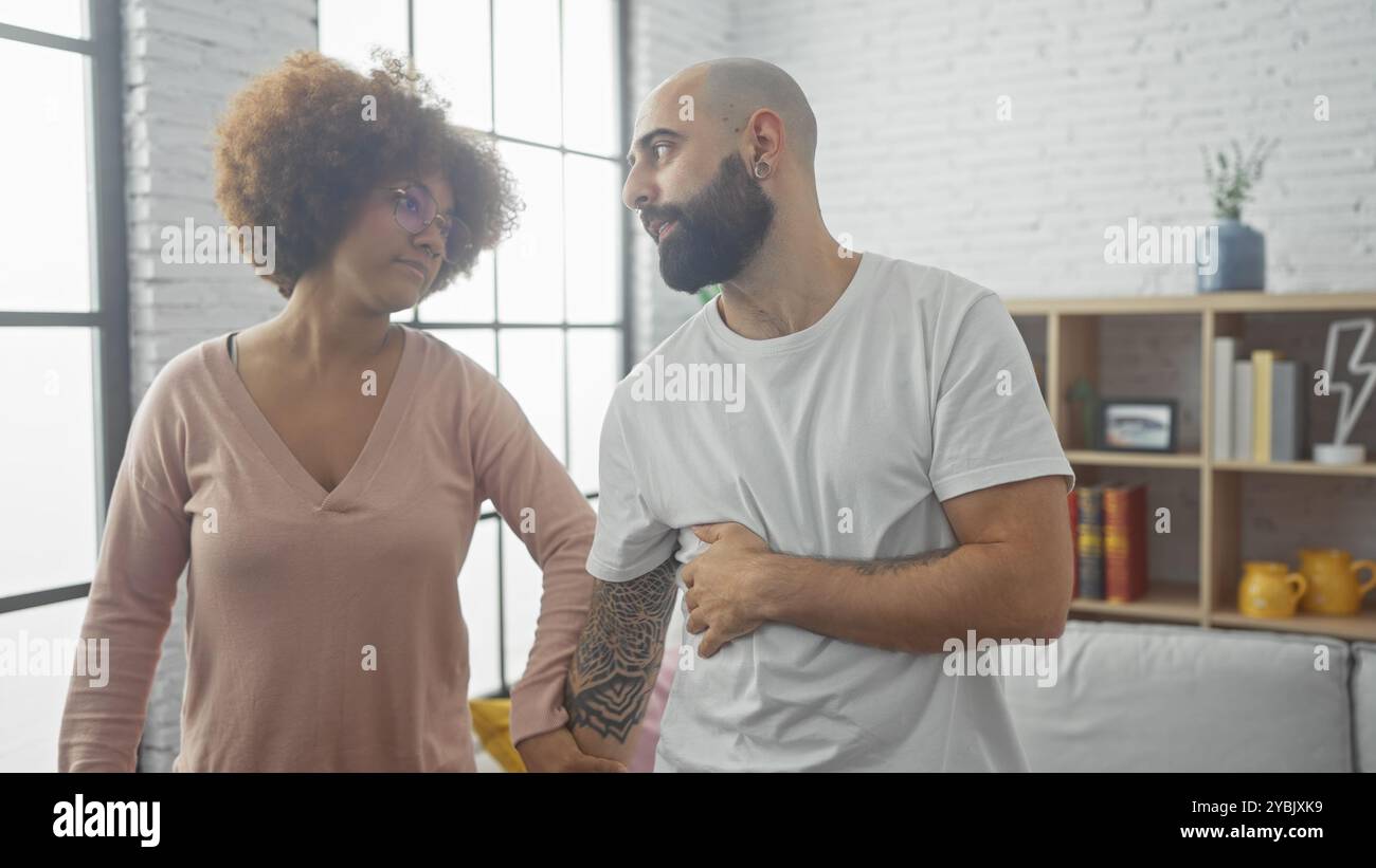Ein Mann und eine Frau in einem modernen Wohnzimmer, die Augen in einem offenen, intimen Moment schließen, die städtische Liebe und Zweisamkeit verkörpern. Stockfoto