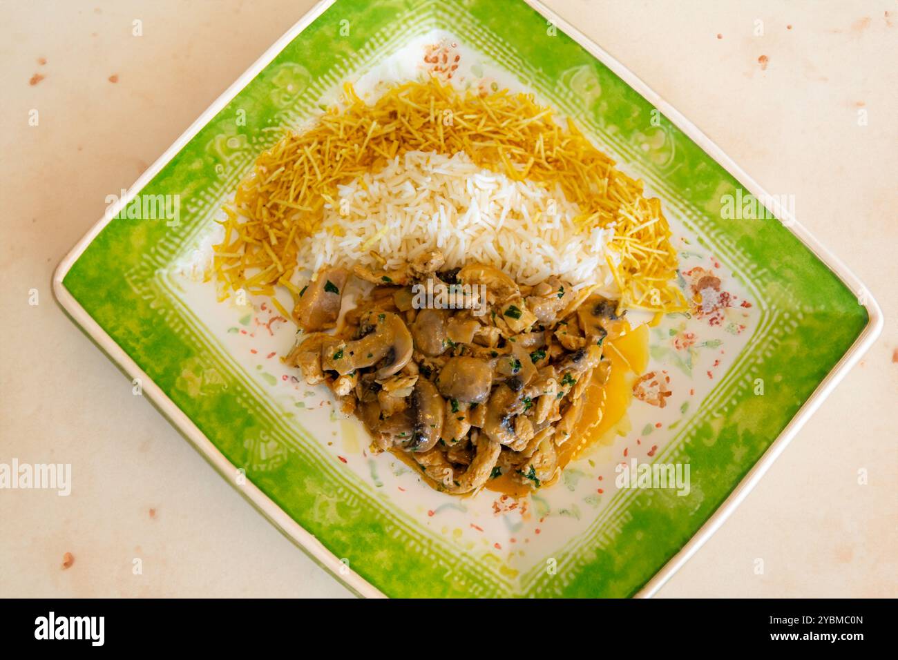 Traditionelles Hühnerstroganoff mit Pilzen, Strohkartoffeln und weißem Reis Stockfoto