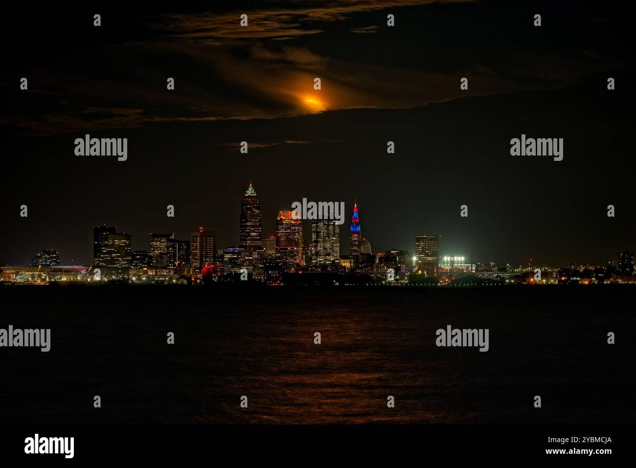 Vollmond im September, der aus Wolken über Cleveland, Ohio und dem Eriesee auftaucht Stockfoto