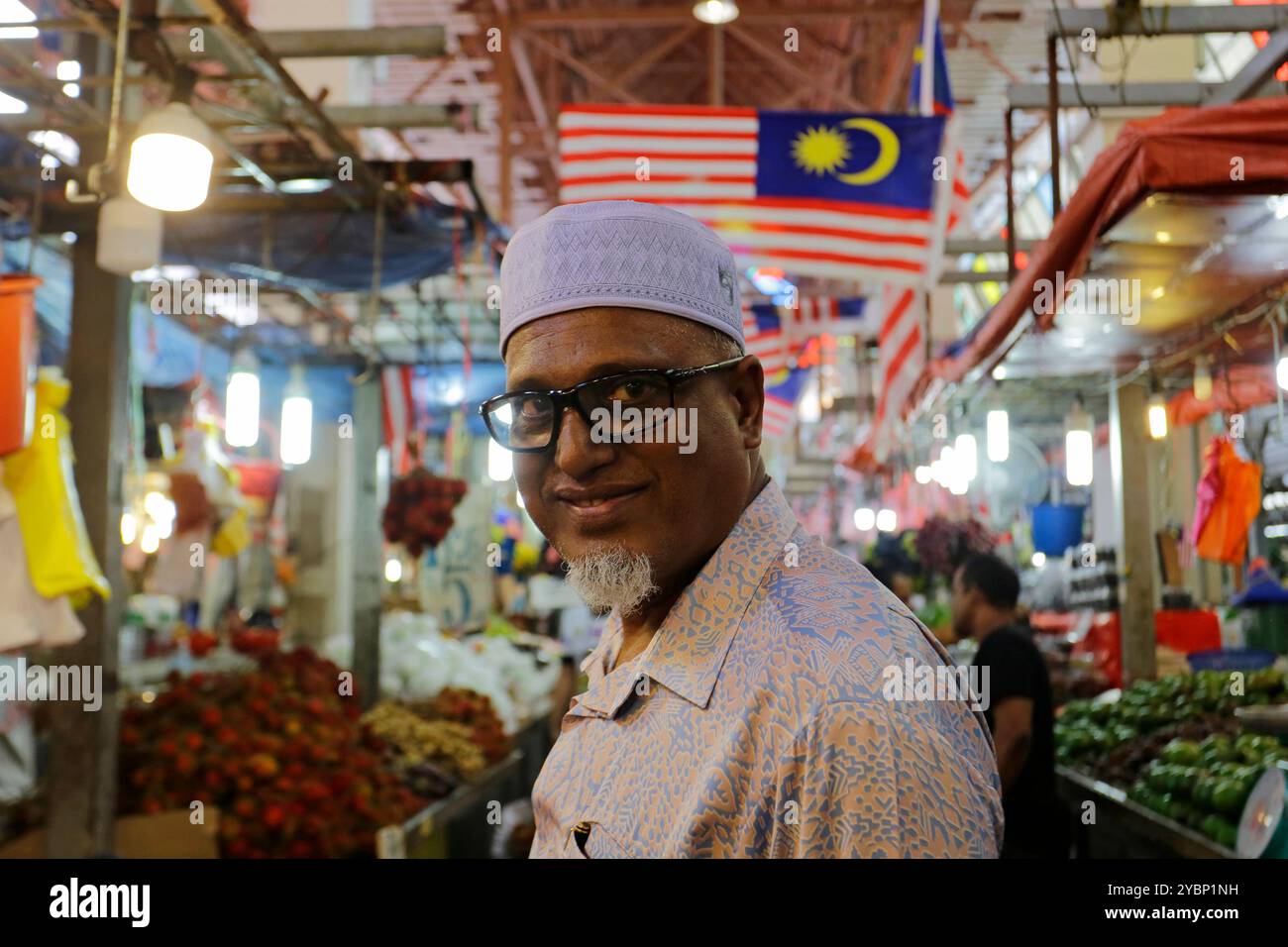 Kuala Lumpur, Malaysia – 3. August 2023: Ein malaysischer Mann posiert für ein Porträt im Obst- und Gemüsesektor des Chow Kit Market. Stockfoto