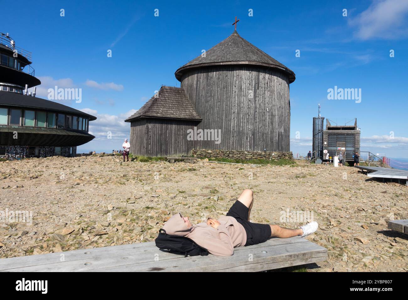 Junger Mann, der sich auf der Bank entspannt Kapelle des Heiligen Lorenz auf dem Berg Snezka Sniezka Polen Europa Stockfoto