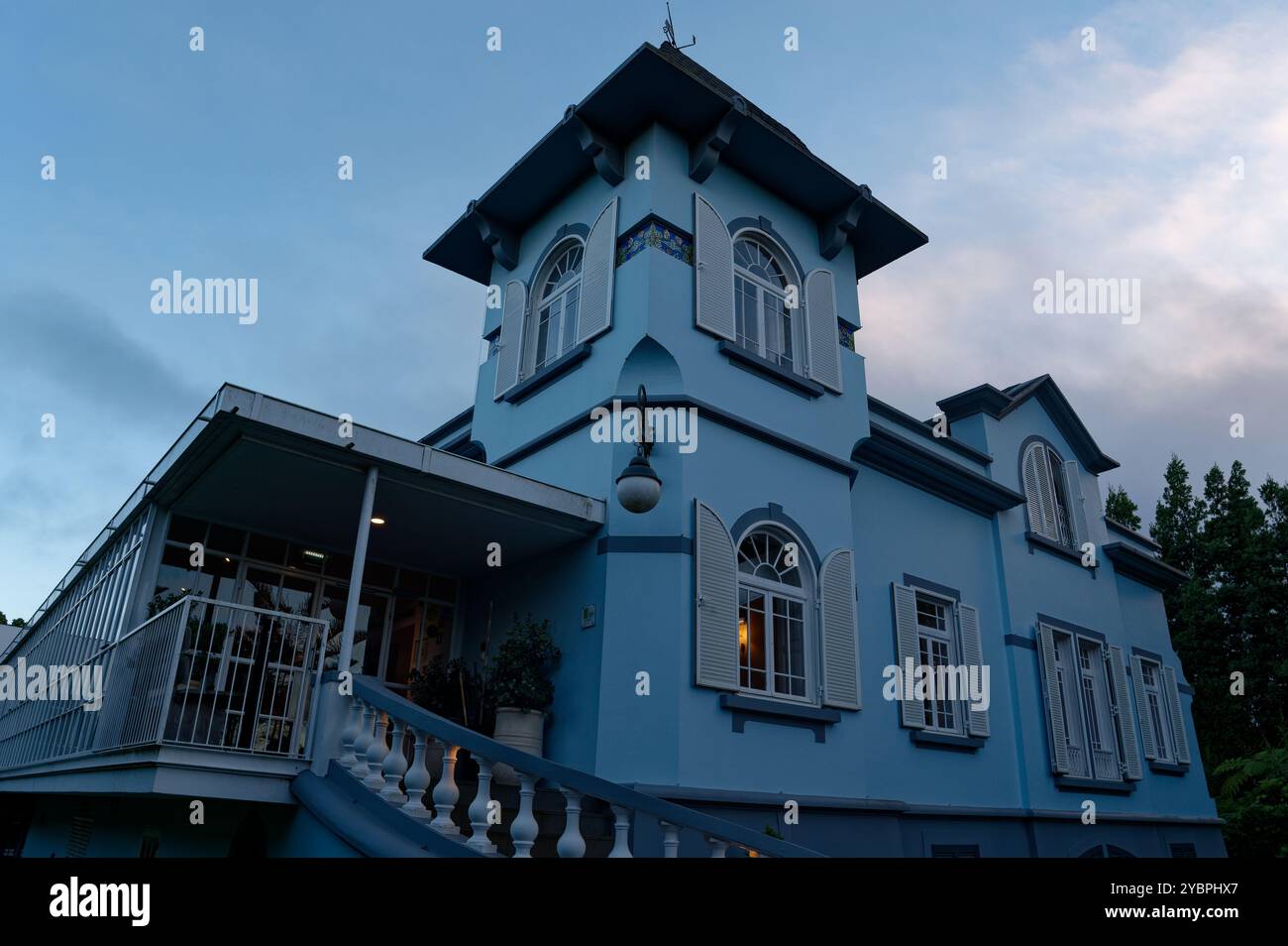 Elegantes blaues Gebäude im Kolonialstil mit Bogenfenstern in der Abenddämmerung in Santo António da Serra Stockfoto