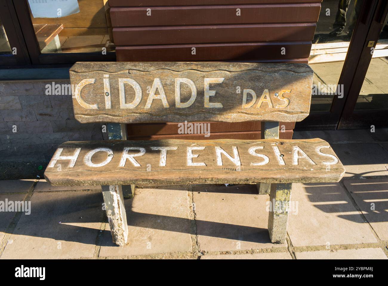 Canela, Brasilien - 15. Oktober 2024: Cidade das Hortênsias (Stadt der Hortensien) auf einer Holzbank am Busbahnhof von Canela geschrieben Stockfoto