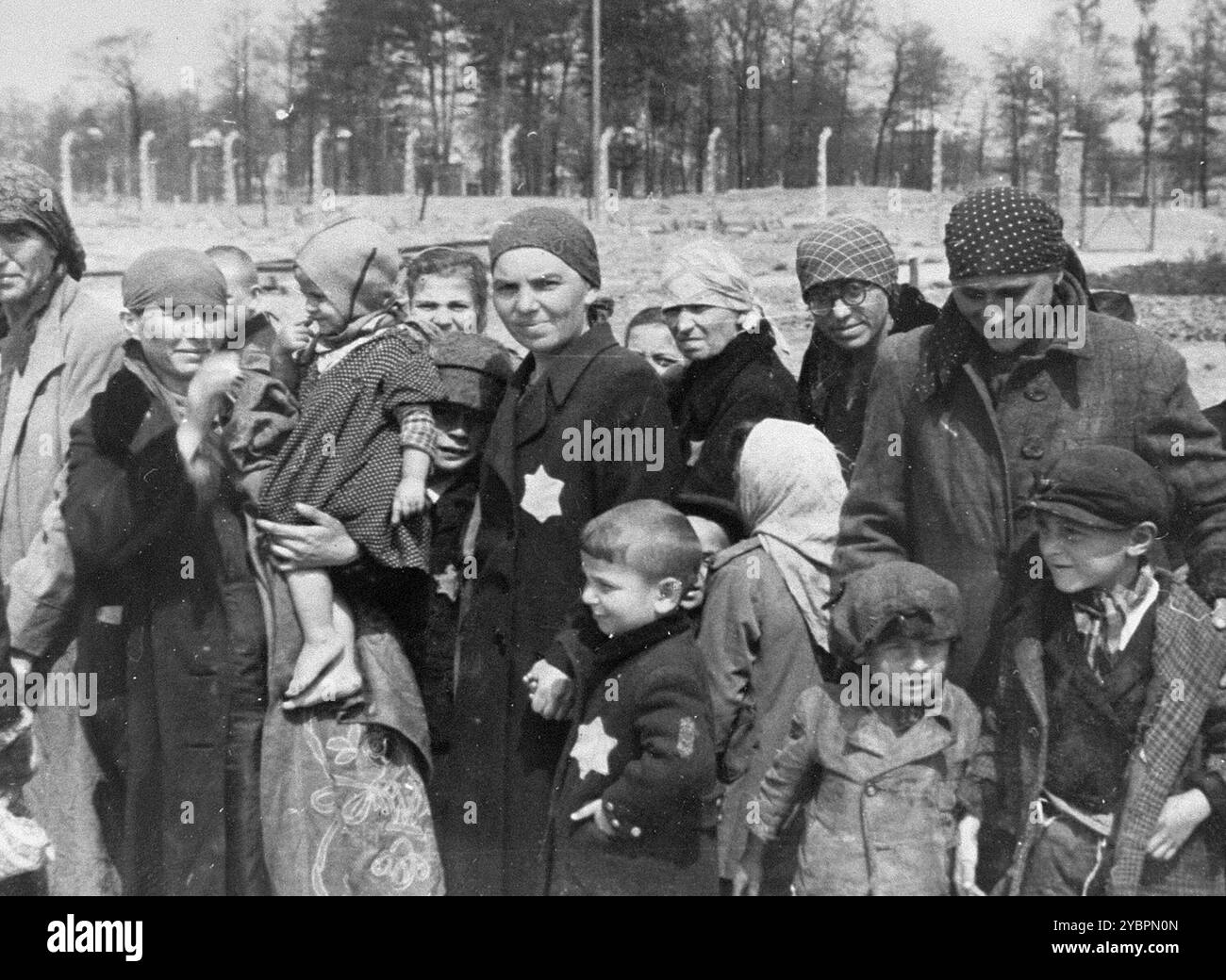 Jüdische Frauen und Kinder aus Ungarn, die in Auschwit zum Tod ausgewählt wurden, warten darauf, in die Gaskammern gebracht zu werden. Die Juden in Ungarn waren ziemlich sicher, bis Hitler aus Angst, Ungarn würde einen Vertrag mit den Alliierten suchen, die Invasion des Landes im März 1944 anordnete. Zwischen dem 15. Mai und dem 9. Juli 1944 wurden über 434.000 Juden mit 147 Zügen deportiert, die meisten nach Auschwitz, wo etwa 80 Prozent bei der Ankunft vergast wurden. Der schnelle Fortschritt der Deportationen wurde durch die enge Zusammenarbeit zwischen den ungarischen und deutschen Behörden ermöglicht. Stockfoto