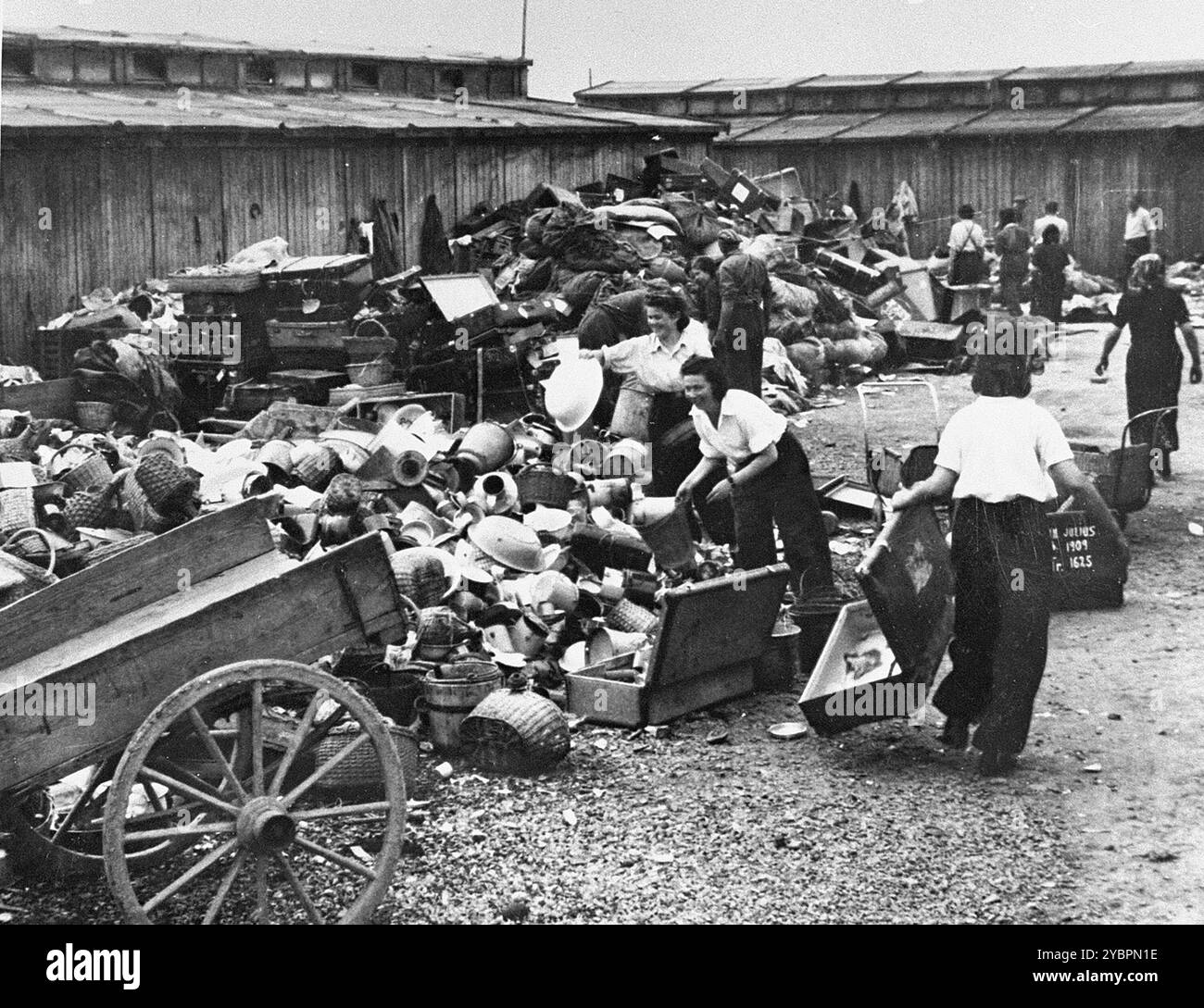 Gefangene des Aufräumungskommandos entladen das konfiszierte Eigentum eines Transports ungarischer Juden in einem Lager in Auschwitz. Die Juden in Ungarn waren ziemlich sicher, bis Hitler aus Angst, Ungarn würde einen Vertrag mit den Alliierten suchen, die Invasion des Landes im März 1944 anordnete. Zwischen dem 15. Mai und dem 9. Juli 1944 wurden über 434.000 Juden mit 147 Zügen deportiert, die meisten nach Auschwitz, wo etwa 80 Prozent bei der Ankunft vergast wurden. Der schnelle Fortschritt der Deportationen wurde durch die enge Zusammenarbeit zwischen den ungarischen und deutschen Behörden ermöglicht. Stockfoto