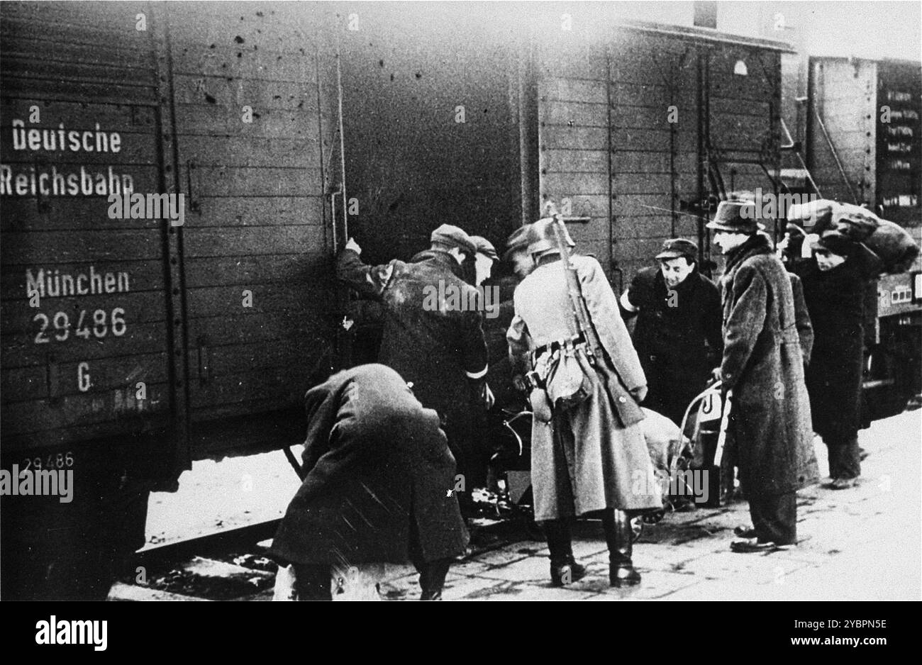 Ein SS-Mitglied überwacht die Einschiffung von Juden in Züge während einer Deportationsaktion im Krakauer Ghetto. Das Krakauer Ghetto wurde 1942/43 liquidiert und fast alle Einwohner wurden nach Belzec und Auschwitz geschickt. Einige der fähigen Menschen wurden in Sklavenarbeitslager geschickt. Stockfoto