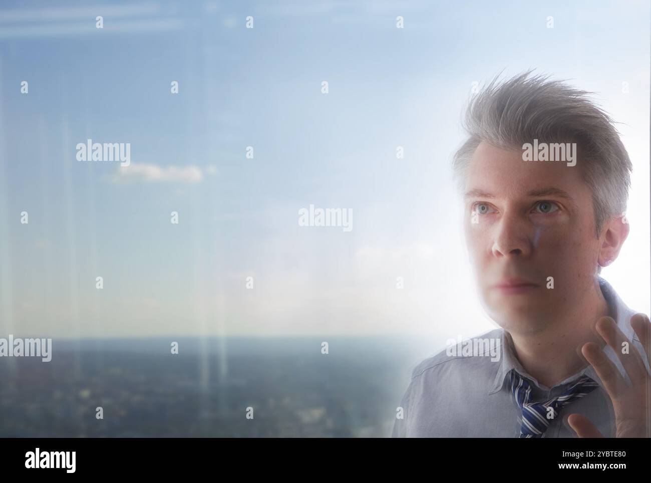 Erhöhte Ansicht Reflexion einer kaukasischen Geschäftsmann auf der Suche aus einem Büro Fenster Stockfoto