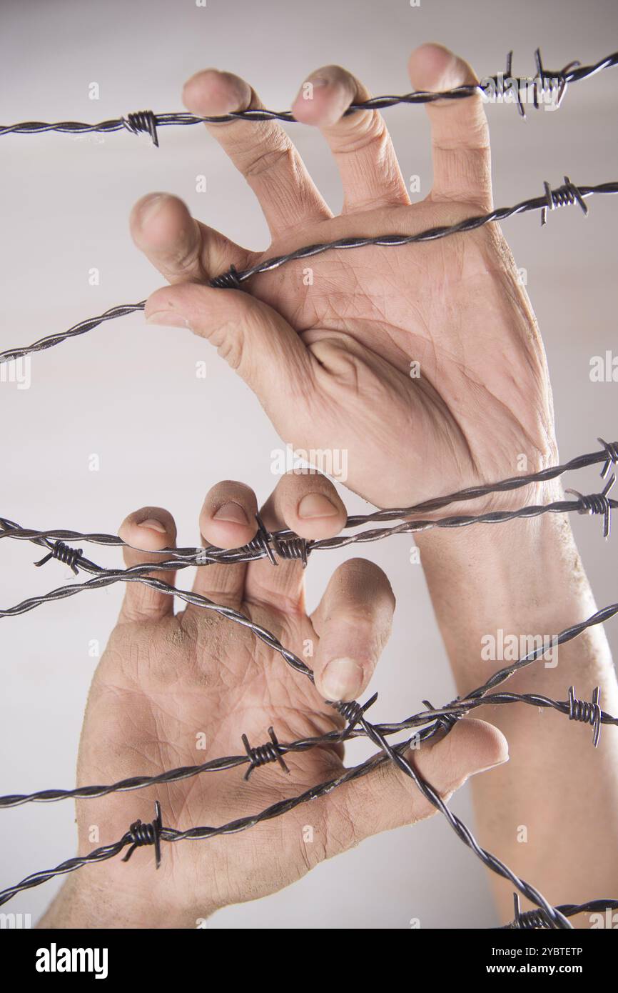 Hände greifen der Stacheldraht im Zeichen weg mit dem weißen Hintergrund zu laufen Stockfoto