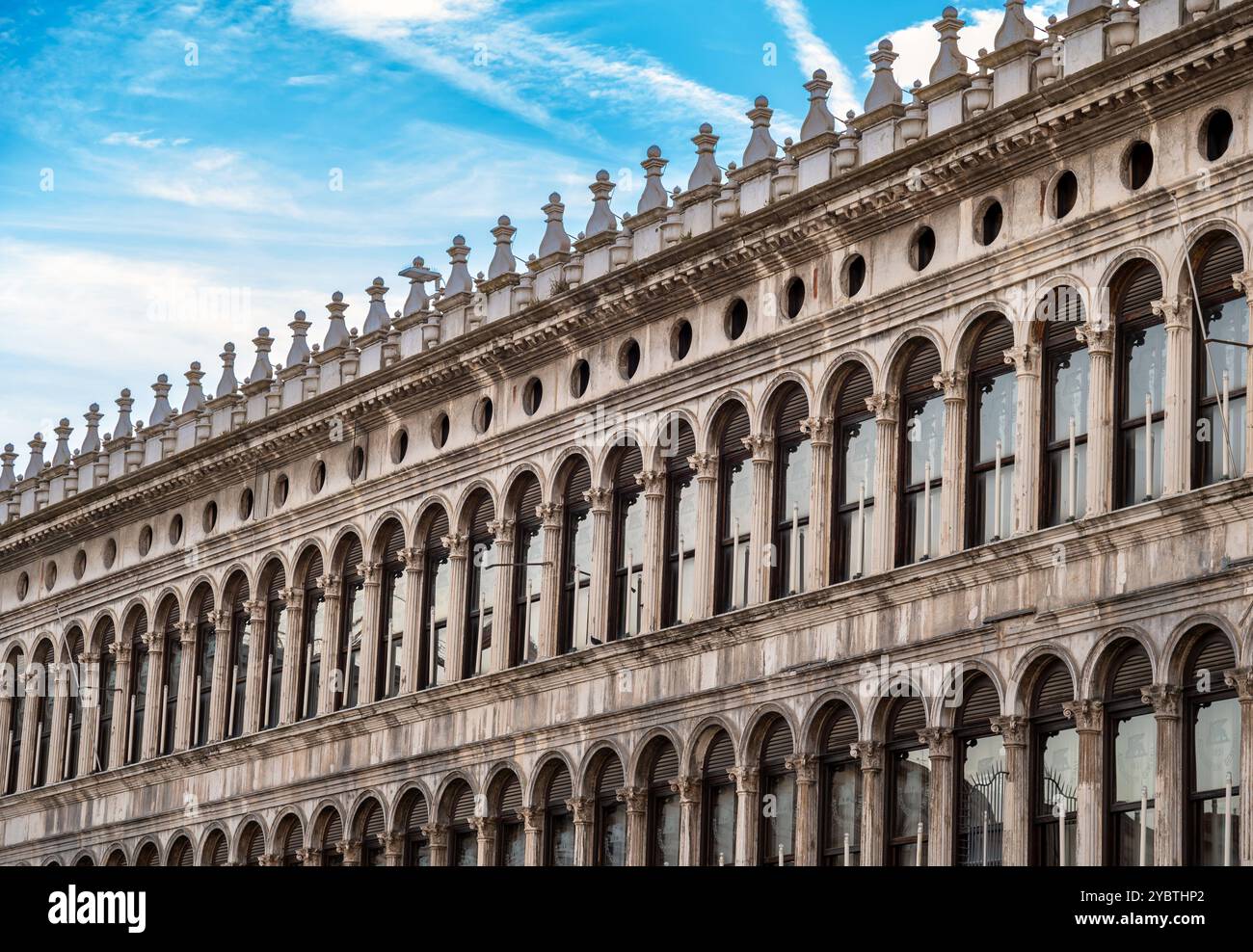 Historische Procuratie Vecchie Piazza San Marco Gebäude mit Bogenfenstern in der Stadt Venedig Italien Europa unter blauem Himmel mit Wolken Stockfoto