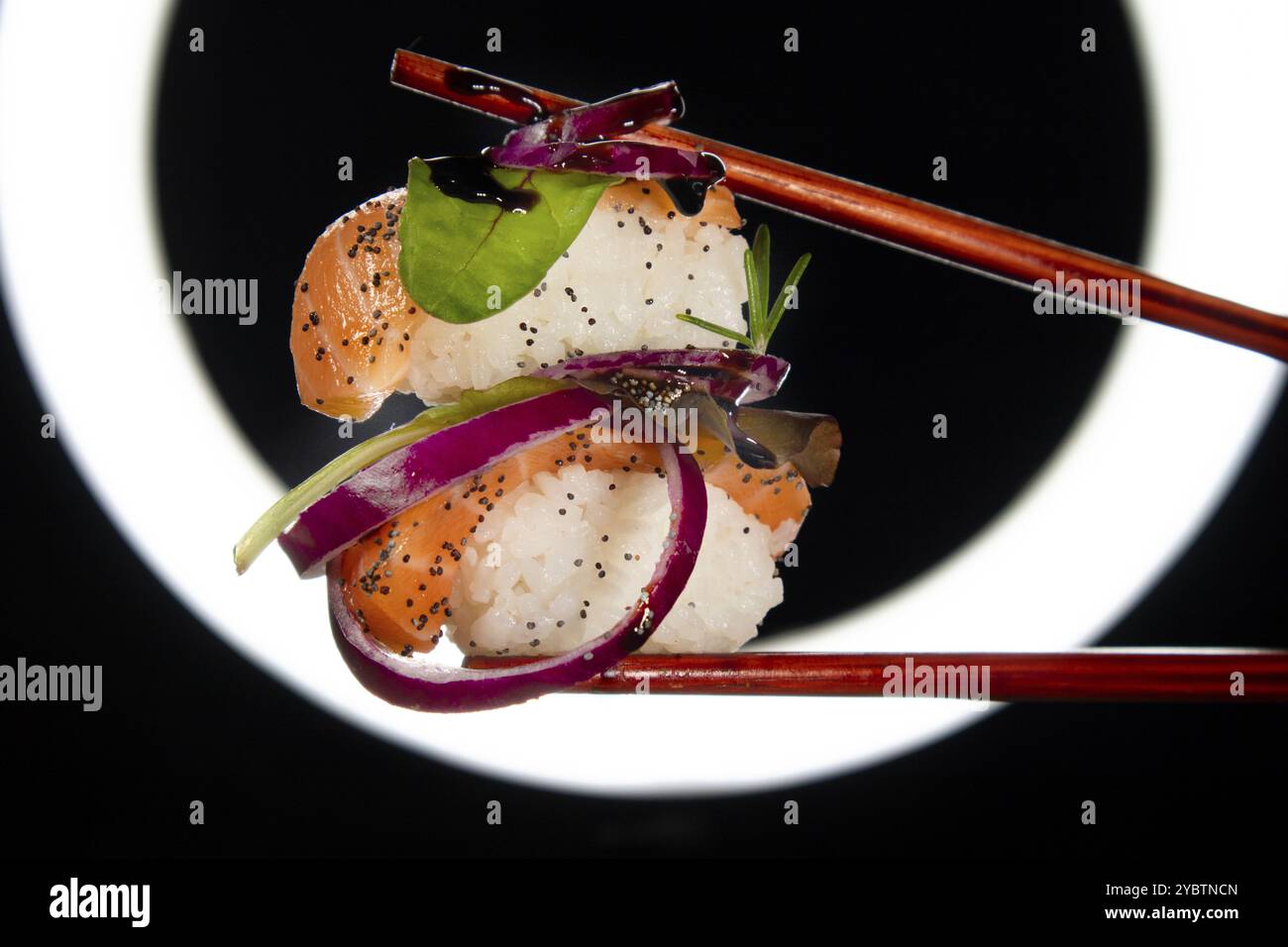 Präsentation einer Portion Sushi mit Beilage auf der Basis roter Zwiebeln Stockfoto