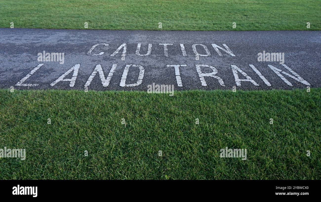 Achtung Straßenschild Land Train Warnung. Warnung vor dem 'Zug', der an der Küste von Bridlington, einem Resort an der Ostküste, entlang fährt und Passagiere von Norden nach Süden befördert. Lackiert auf Asphalt. Wer braucht HS2? Stockfoto